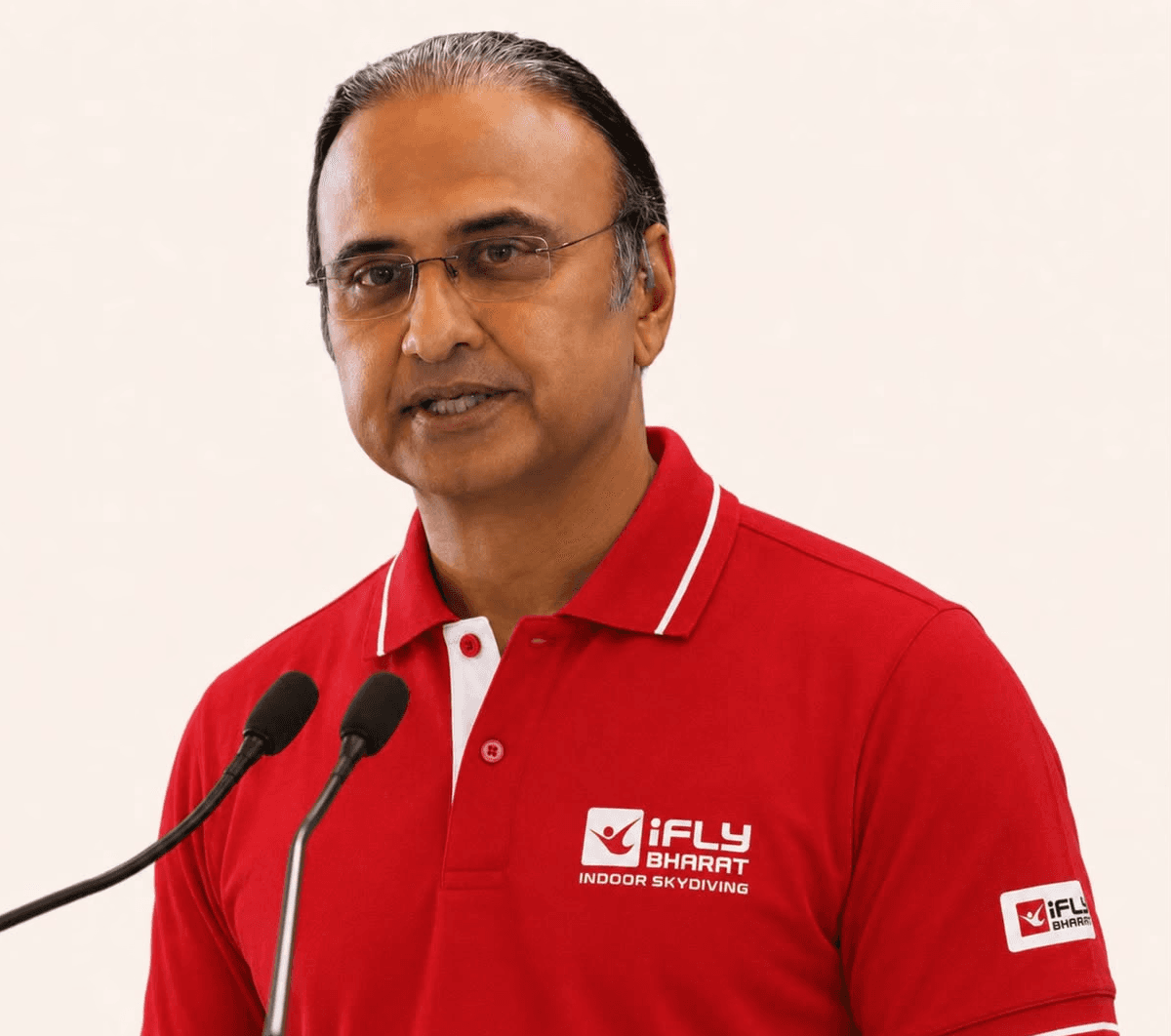 Charu Sharma speaking about indoor skydiving at a microphone